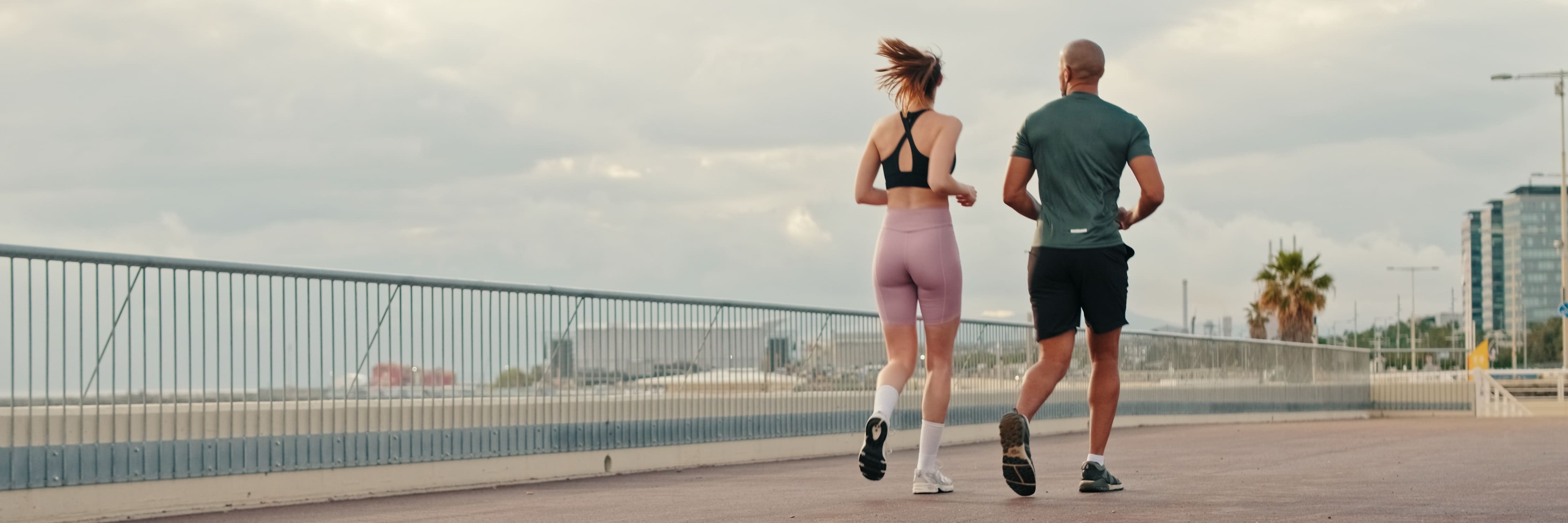 Junges sportliches Paar joggt gemeinsam, von hinten