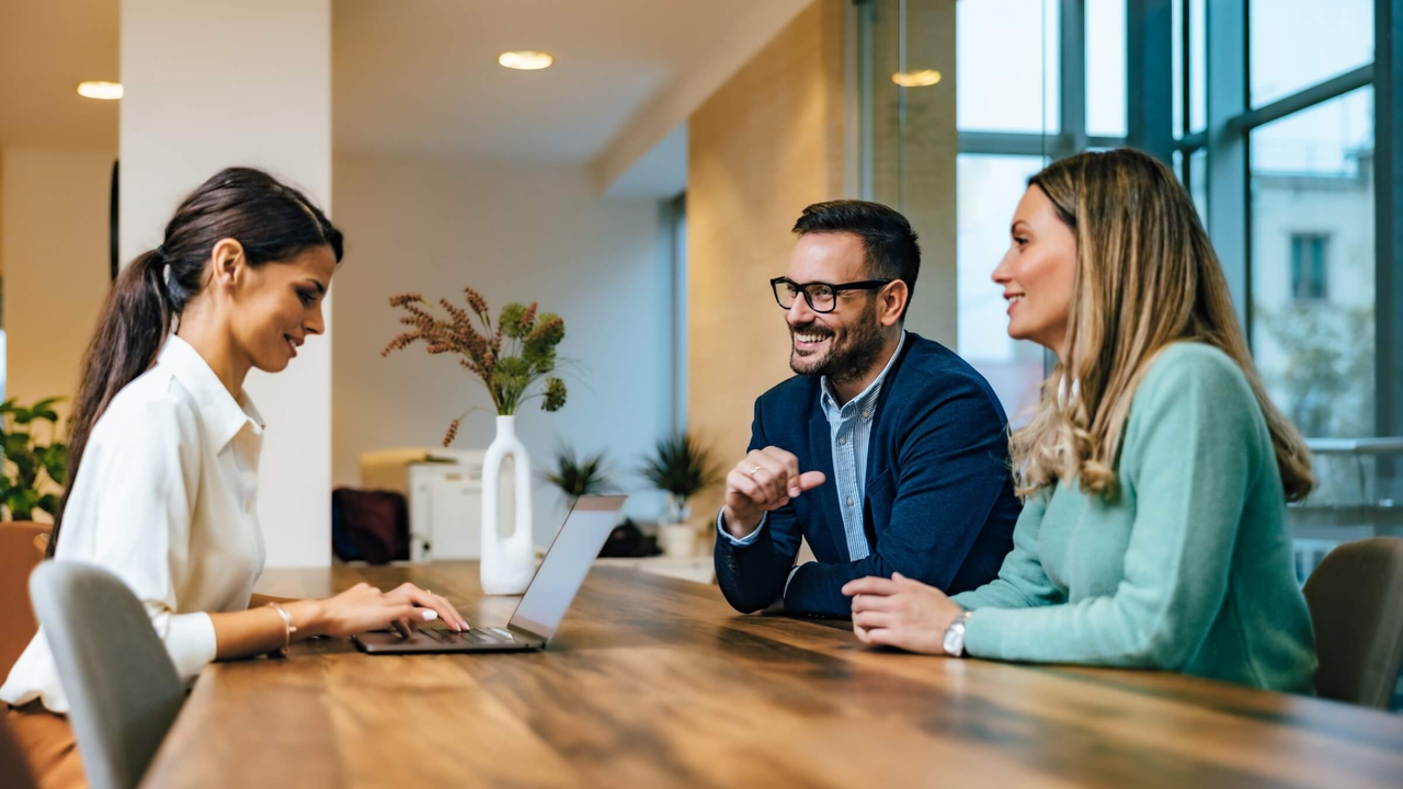Business-Meeting mit lächelnden Fachkräften an einem Holztisch