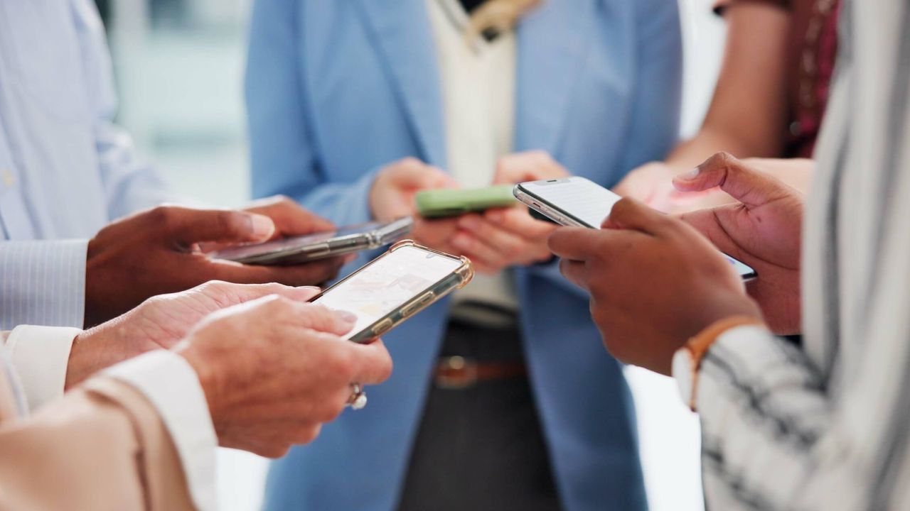 Businessleute nutzen gemeinsam Smartphones und vernetzen sich im Team