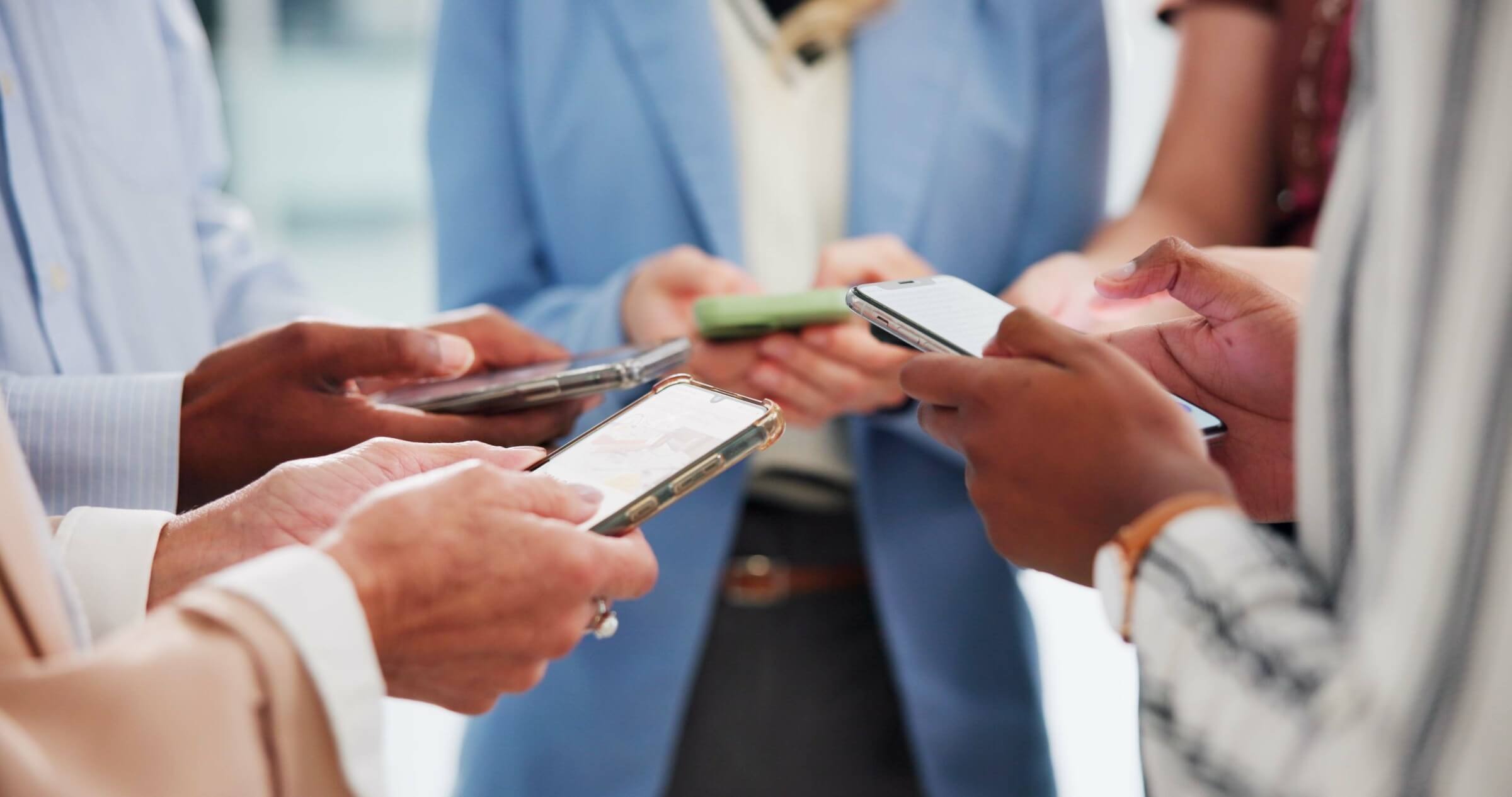Businessleute nutzen gemeinsam Smartphones und vernetzen sich im Team