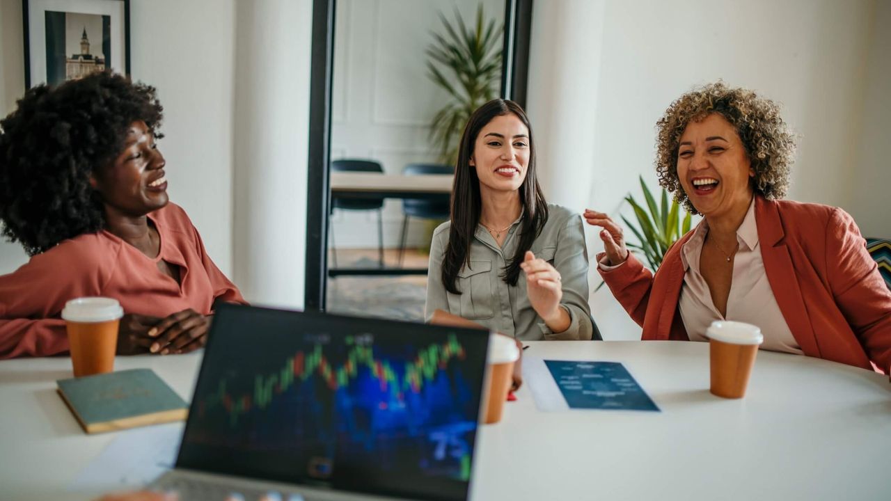 Fröhliche Frauen arbeiten gemeinsam an einer Geschäftsstrategie in einem modernen Büro