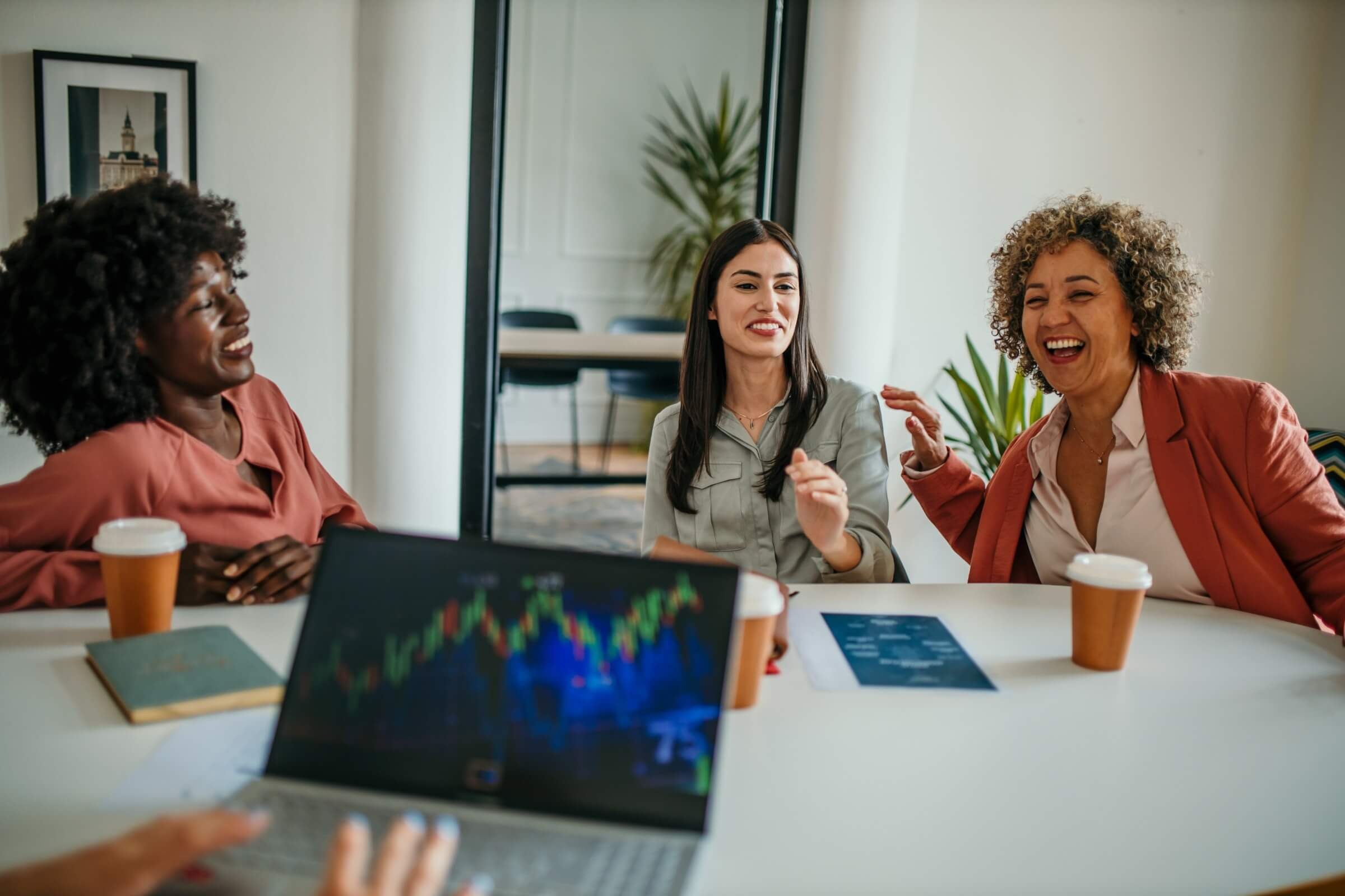 Fröhliche Frauen arbeiten gemeinsam an einer Geschäftsstrategie in einem modernen Büro