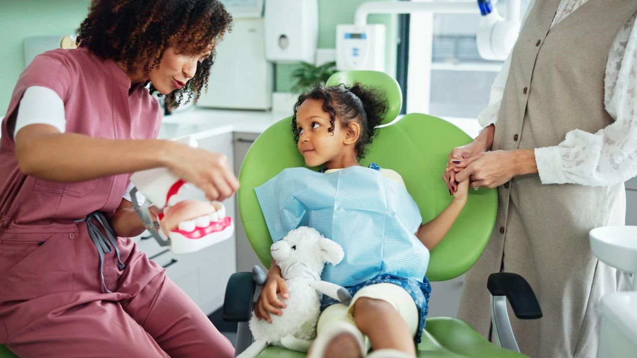 Zahnarzt berät eine Frau mit Kind in der Klinik