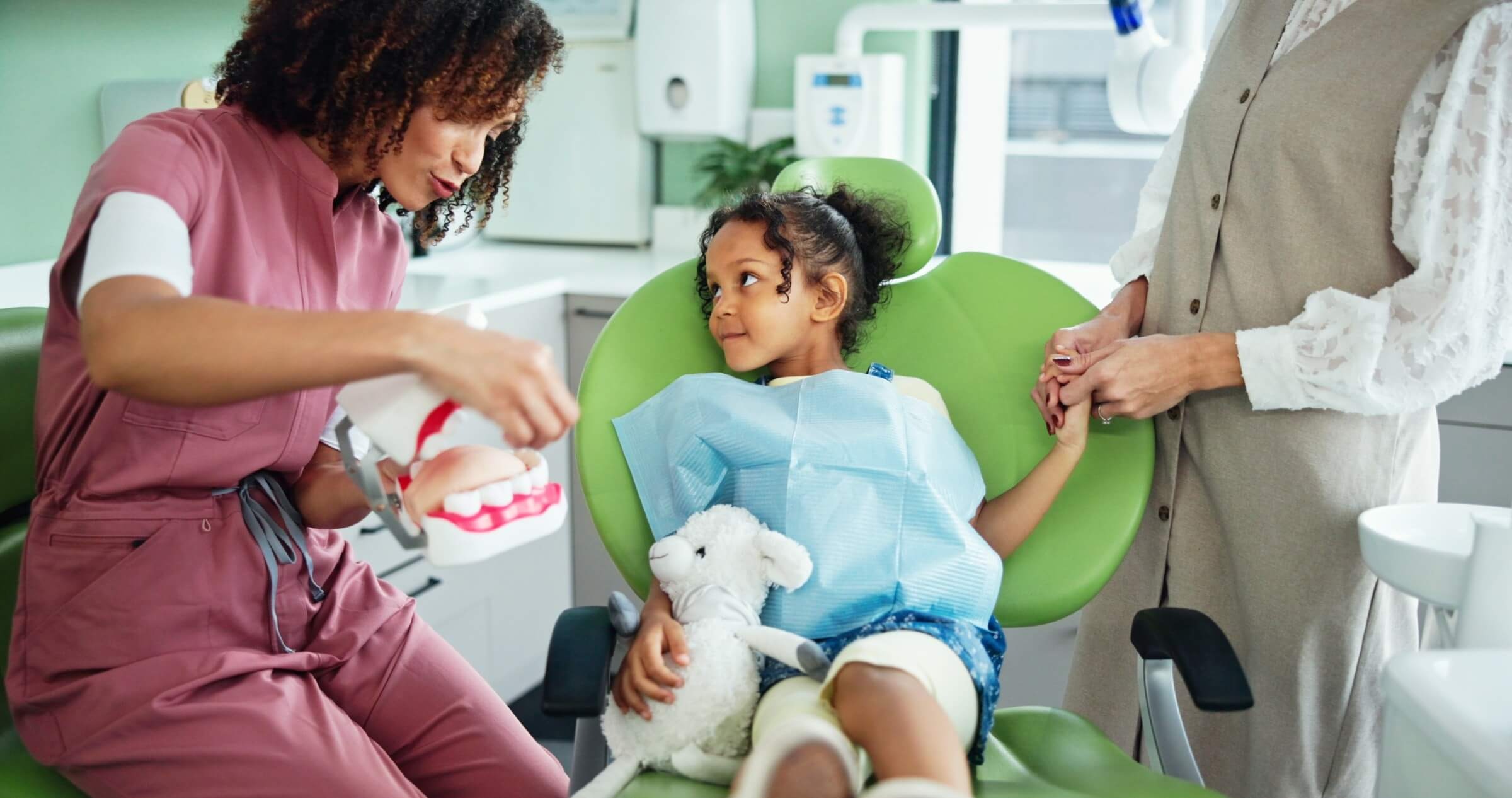 Zahnarzt berät eine Frau mit Kind in der Klinik