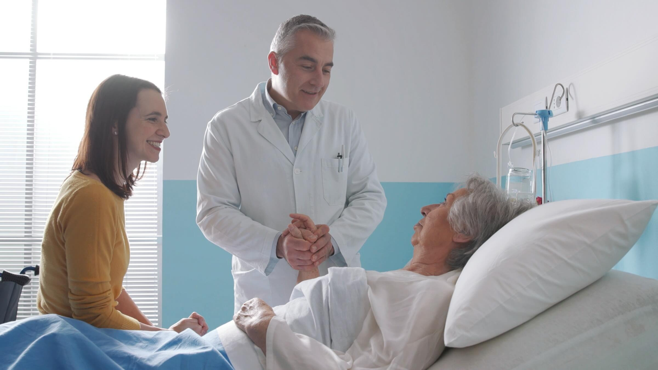 Arzt besucht einen älteren Patienten im Krankenhausbett