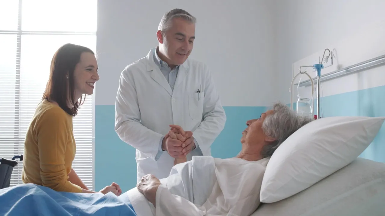 Arzt besucht einen älteren Patienten im Krankenhausbett