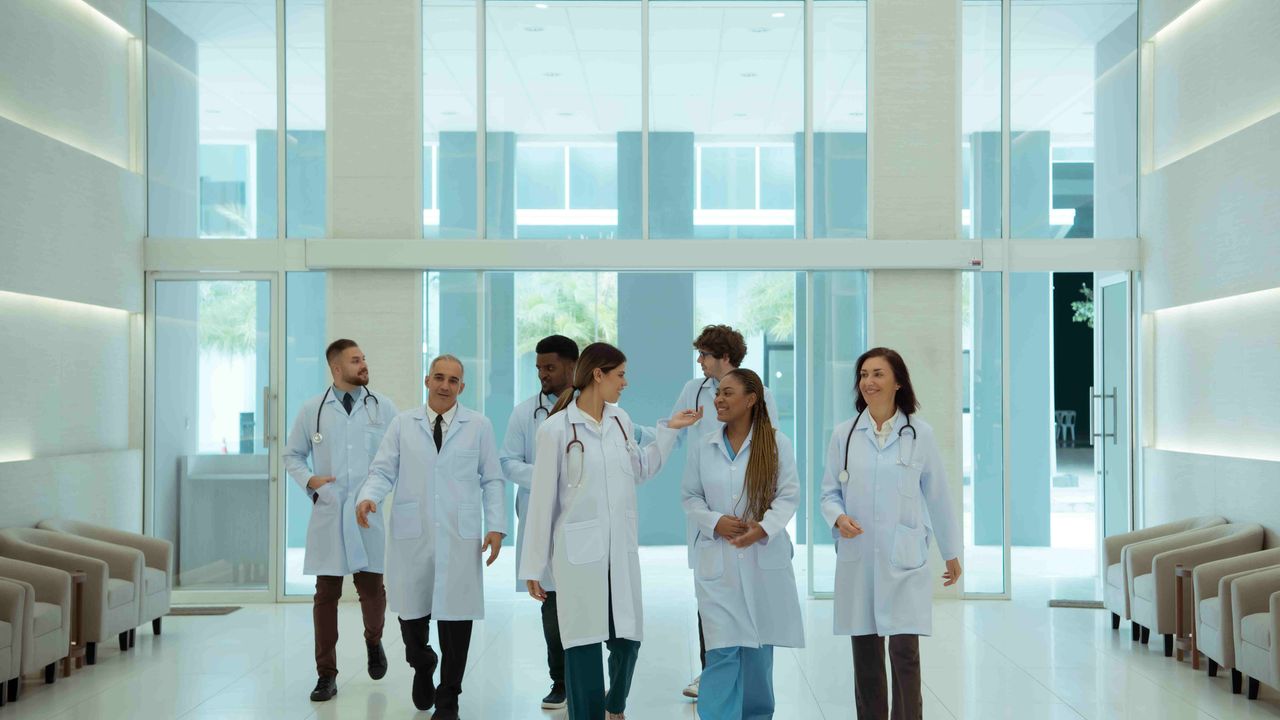 Gruppe von Gesundheitsfachkräften geht durch eine Krankenhauslobby