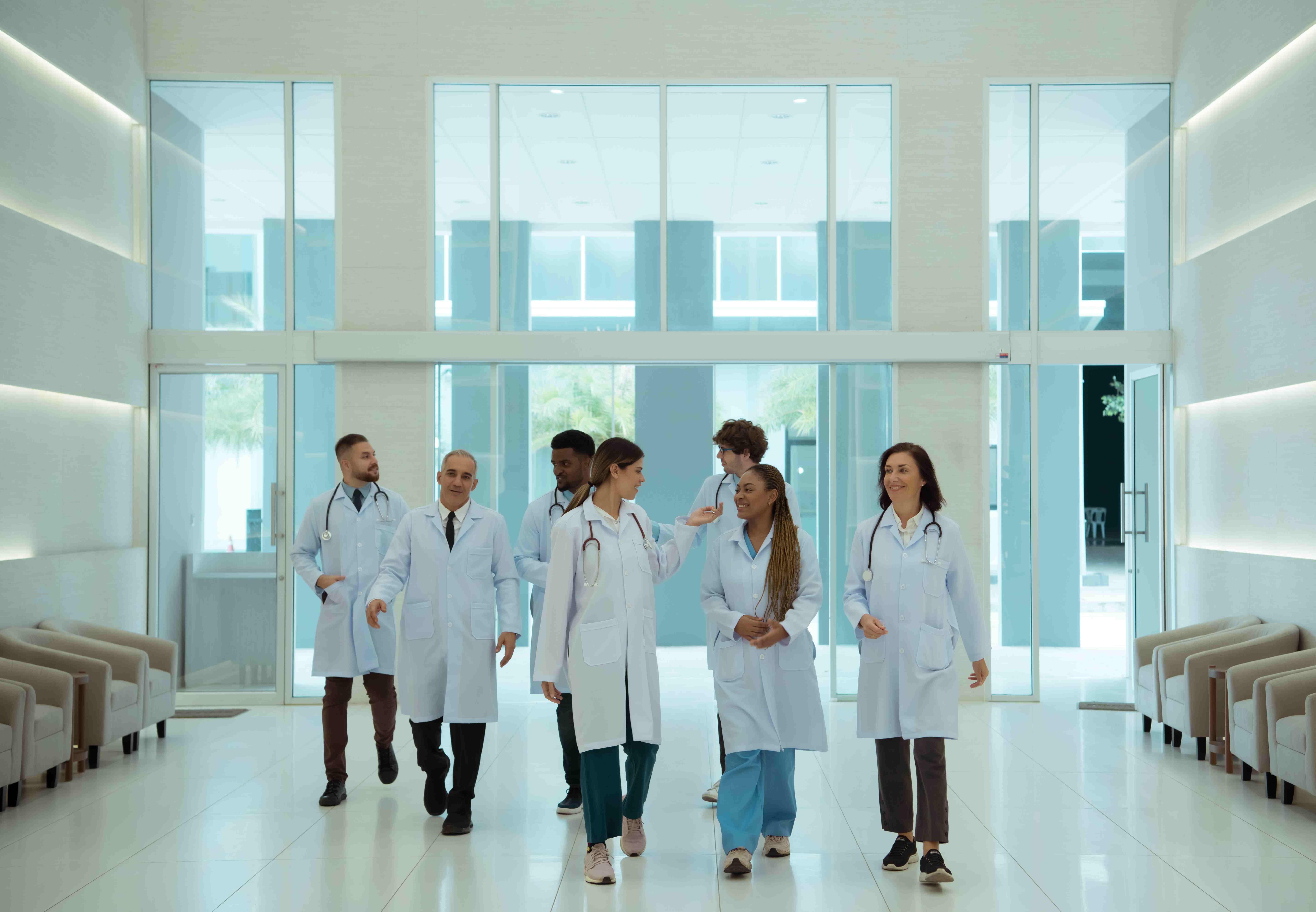 Gruppe von Gesundheitsfachkräften geht durch eine Krankenhauslobby