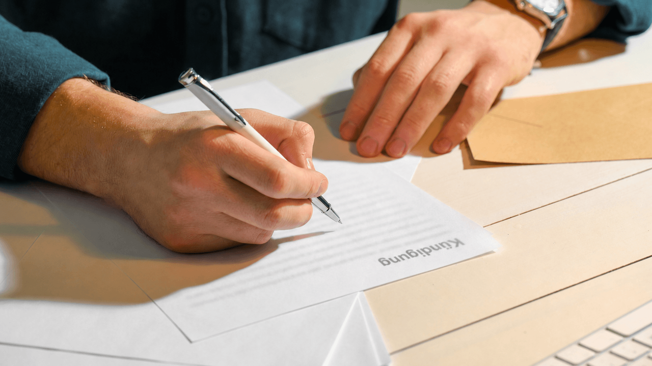Hand mit stift und brief kündigung