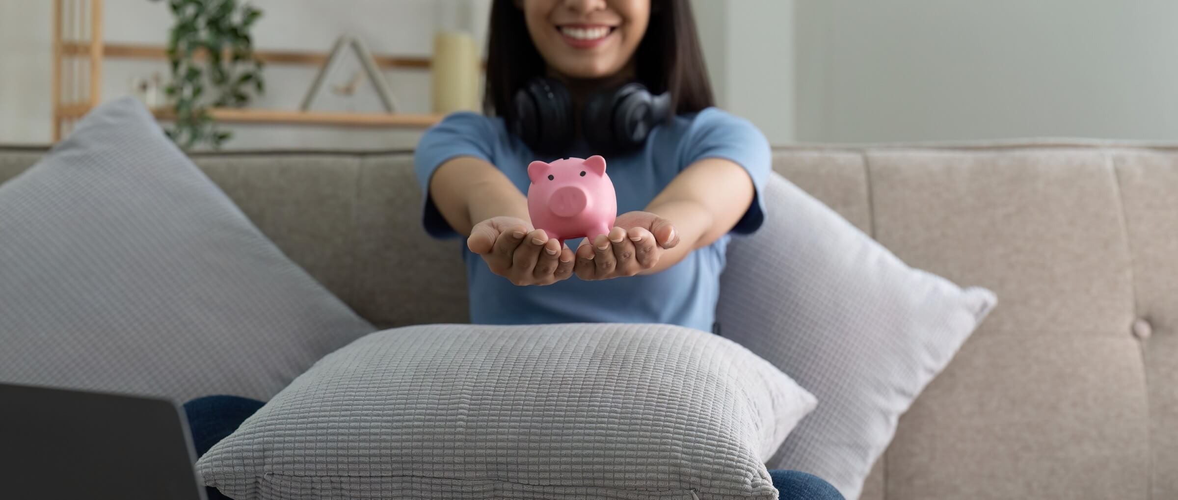 Hände einer Frau halten ein rosa Sparschwein – Konzept des Sparens und der finanziellen Vorsorge