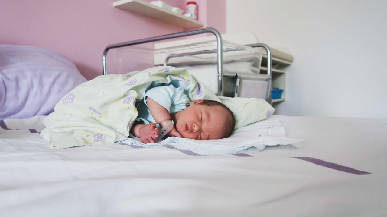 Neugeborenes Baby schläft friedlich in einem Krankenhauszimmer