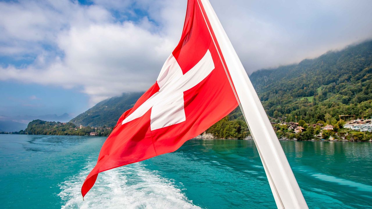 Malerischer Seeblick mit Schweizer Flagge auf einem Boot