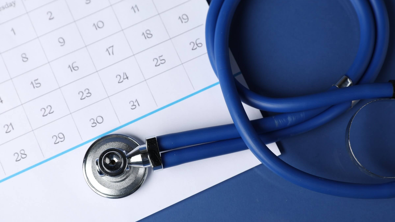 Stethoskop und Kalender auf blauem Hintergrund, Ansicht von oben