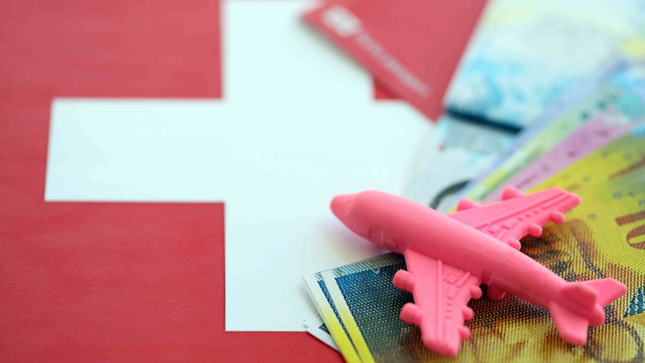 Reiseplanung mit Spielzeugflugzeug und Schweizer Franken