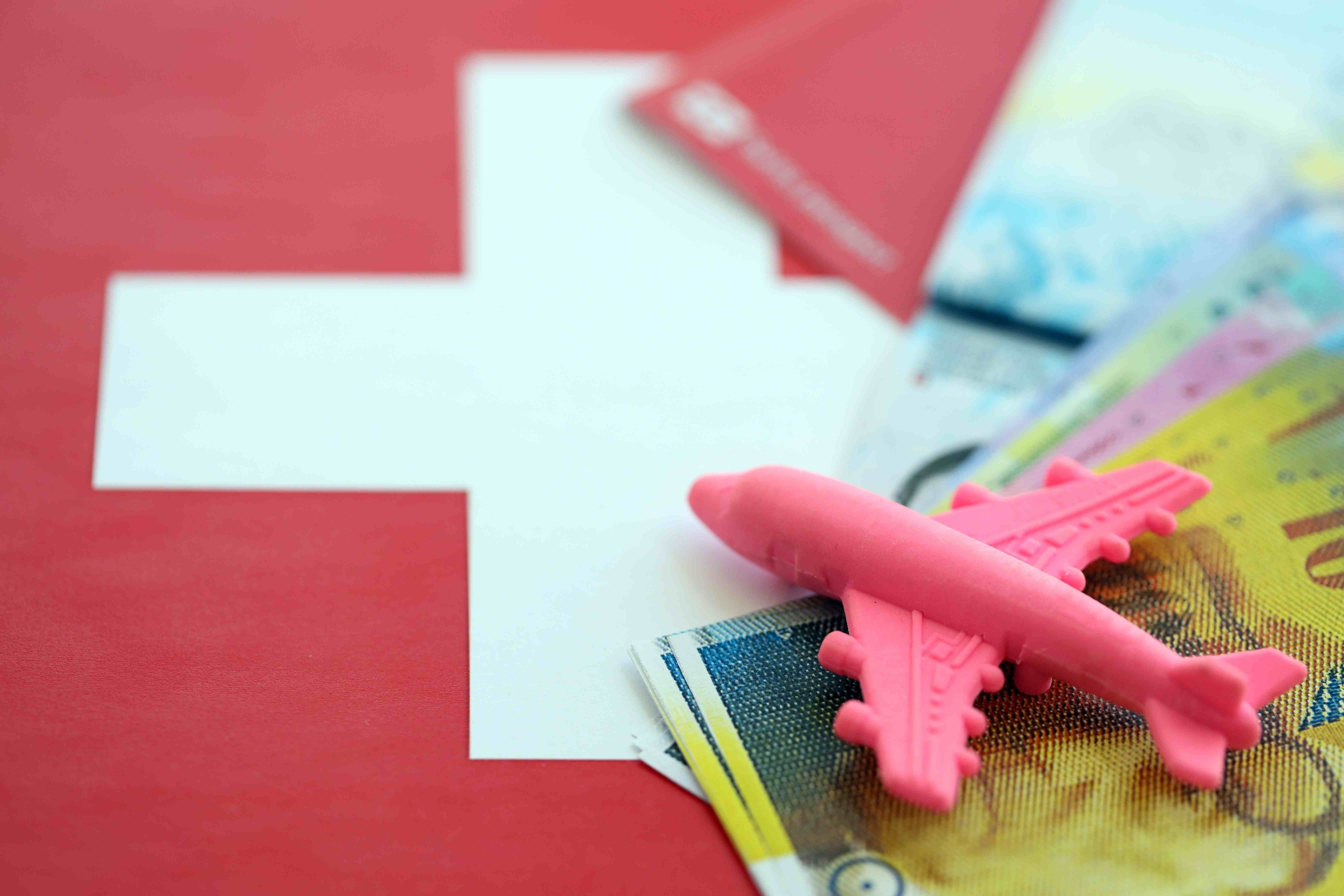 Reiseplanung mit Spielzeugflugzeug und Schweizer Franken