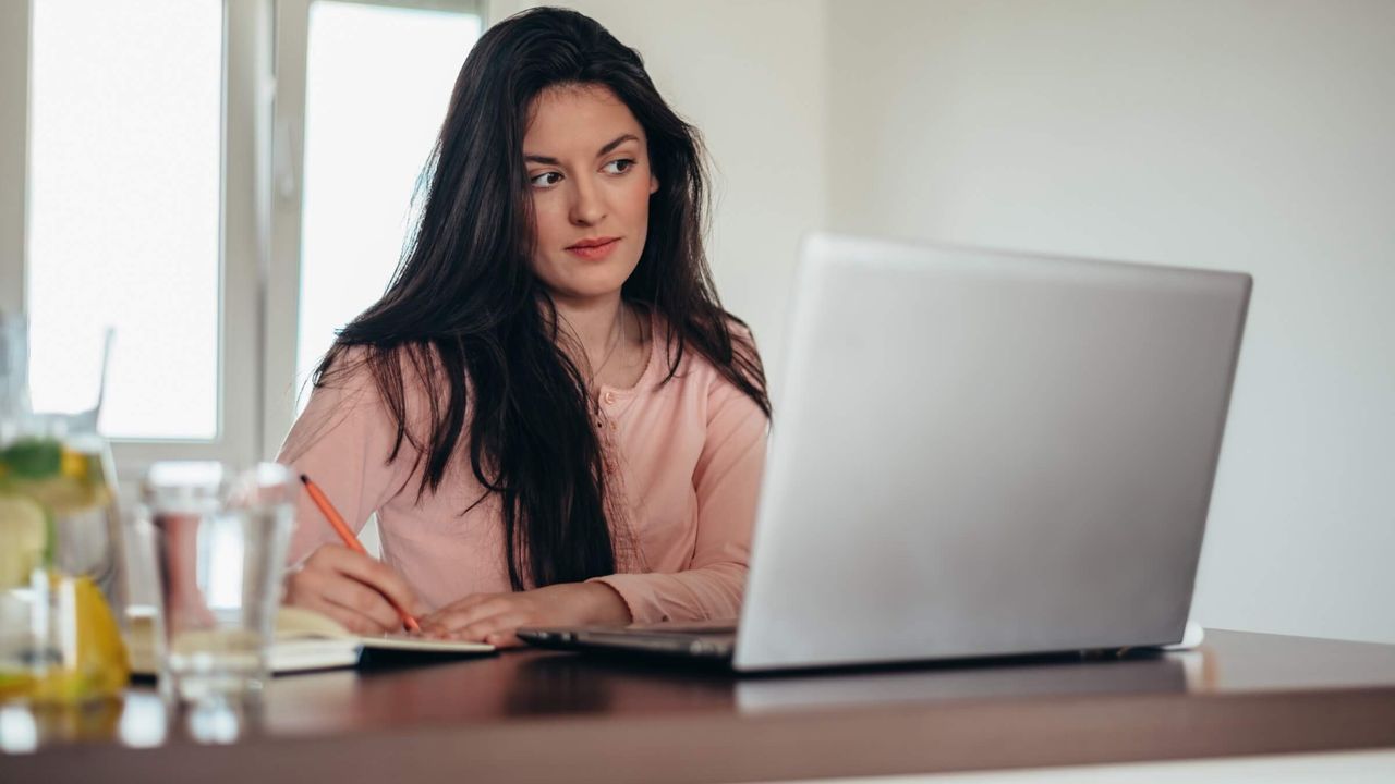 Frau arbeitet zuhause an einem Laptop